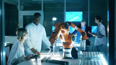 Araştırmacılar bilişim laboratuvarında robotlarla çalışıyorlar.