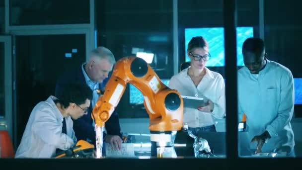 Team of researchers are working with a robot — Wideo stockowe