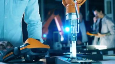 Robot, bir araştırmacı tarafından yönetilirken bir mikroçipin yerini değiştiriyor.