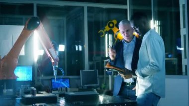 Araştırmacılar bir robotla yapılan deney sırasında konuşuyorlar.