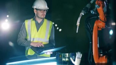 Güvenlik giysisi araştırmacısı bir robotik mekanizmayı yönetiyor.