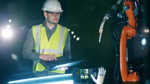 Researcher in safety wear is navigating a robotic mechanism — Wideo stockowe