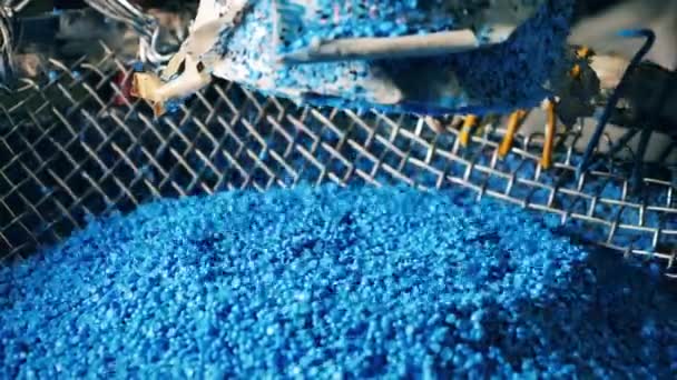 Голубые пластиковые гранулы падают в кучу — стоковое видео