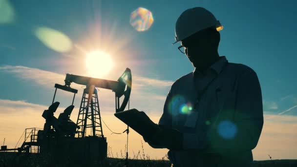 Closeup of engineer typing on tablet at oil field — Video