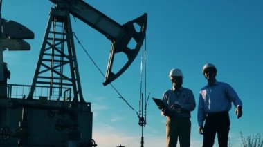 Petrol pompası yakınlarında iş konularını tartışan iki mühendis