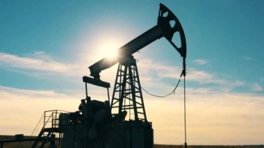 Güneş, petrol sahasında parlayan eşeğin arkasında parlıyor.