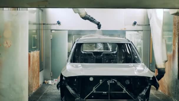 Robotic arms spray painting a vehicle body at a car factory. Automobile factory facility, car production process. — Stock videók