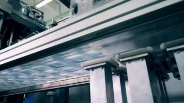 Makine, plastik çarşafların kapaklarını sıkıyor ve onları üst üste yığıyor.