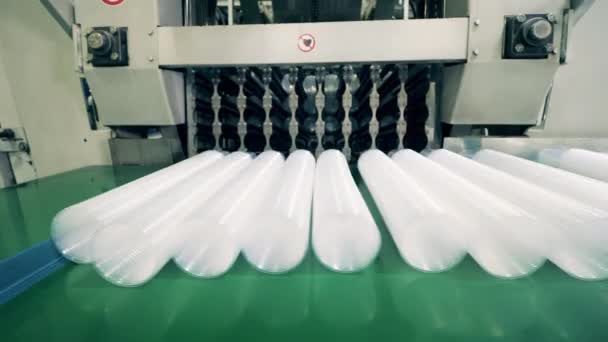 Peralatan produksi mendorong tumpukan gelas plastik ke ban berjalan — Stok Video