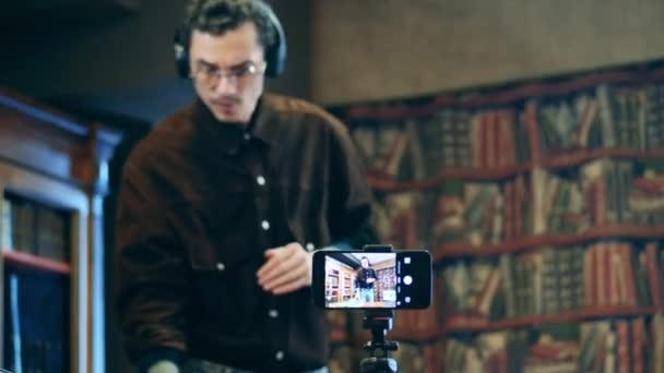 Lautsprecher im Kopfhörer leitet Online-Unterricht über Smartphone-Bildschirm — Stockvideo