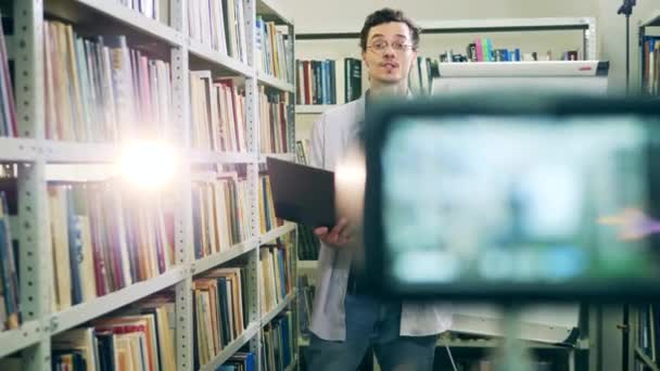 Docent met laptop die formules op flipchart uitlegt aan studenten die thuis studeren — Stockvideo