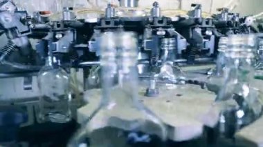 Taşıyıcı makine birçok cam şişenin yerini değiştiriyor.