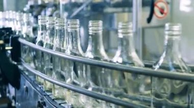Boş cam şişeler mekanik kemer boyunca hareket ediyor.