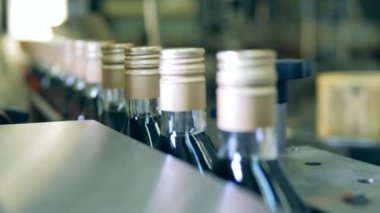 Taşıyıcının içinden geçerken şişelerin boynu mühürlenmiş.