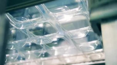 Enjeksiyon kalıplı plastik tepsiler istifleniyor. Alt görünüm.