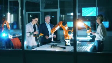 Mühendislerle bir robotik cihaz tartışan bilişim laboratuvarı.