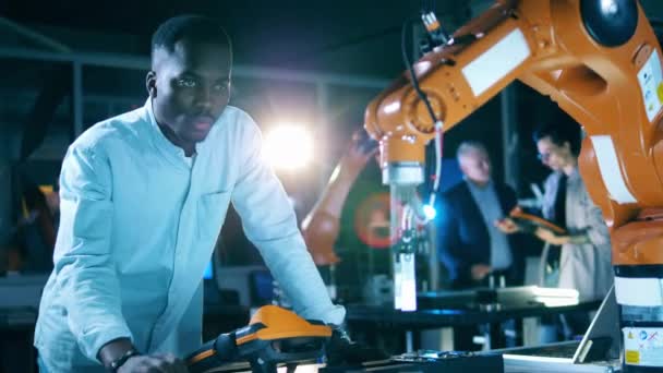 Hombre africano está manejando un dispositivo automatizado en el laboratorio — Vídeo de stock