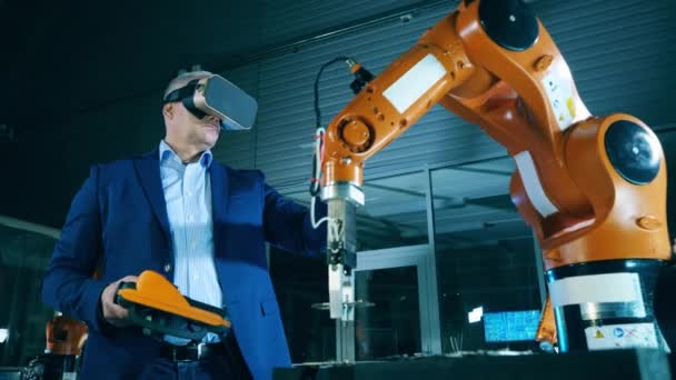 Férfi mérnök a VR-szemüvegben egy robotberendezésen navigál. — Stock videók