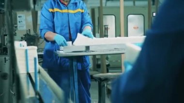 Fabrika personeli taşıma bantlarındaki kağıt mendilleri ayırıyor.