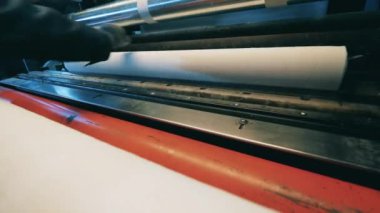 Kağıt parçası bir fabrika makinesi tarafından yaralanıyor.