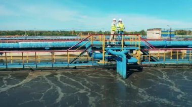 Su yönetimi konsepti. İki uzman biyolojik atık su arıtma tesisinde tartışıyorlar.