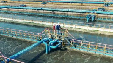 Köprüde temizlik tesisinde konuşan iki işadamı. Su yönetimi kavramı.