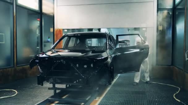 Car factory workers painting a vehicle at a car manufacturing facility — Stock Video