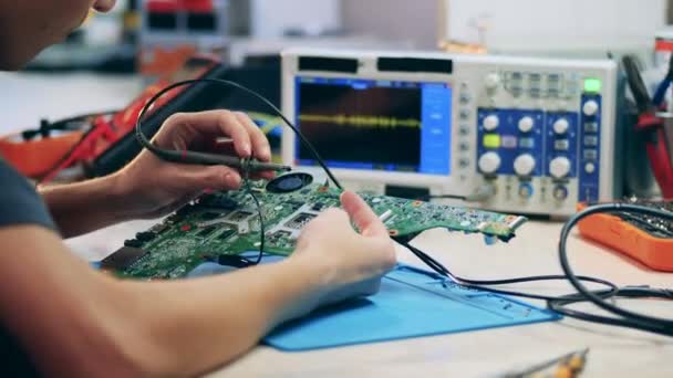 Homme ingénieur est des éléments de soudure d'un circuit — Video