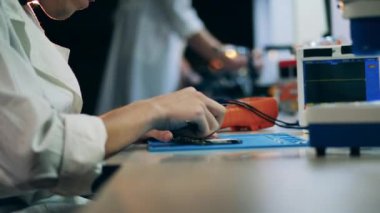 Mühendis bir cep telefonunu söküp tamir ediyor.