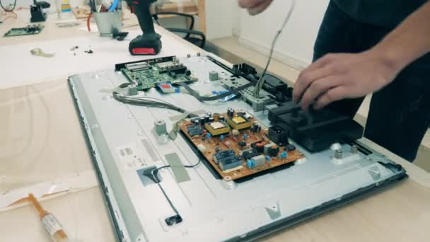 Ingeniero masculino está desmantelando un dispositivo electrónico — Vídeo de stock