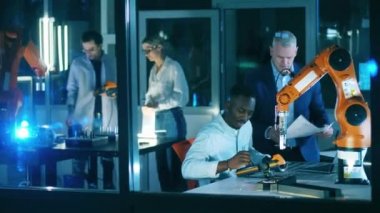 Mühendisler endüstriyel robotu test ediyor. Yenilik, modern teknoloji, fütüristik laboratuvar kavramı.