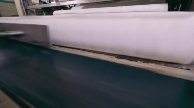 Kağıt mendil ruloları bir fabrika makinesine taşınıyor.