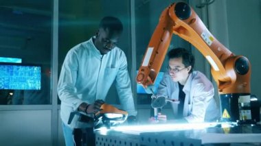 Robot çizim yaparken mühendisler kağıtlara bakar. Yenilik, teknoloji kavramı.