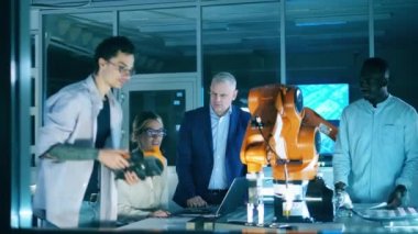 Robot kol hareketi programı üzerinde çalışan mühendisler. Yenilik, modern teknoloji, fütüristik laboratuvar kavramı.
