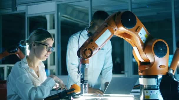 Az egyik mérnök elmagyarázza egy másik ipari robotkarnak az összetett mozdulatokat. Innováció, technológiai koncepció. — Stock videók
