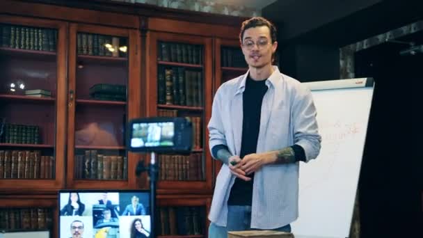 Männlicher Tutor im Gespräch mit Studenten während eines Online-Kurses — Stockvideo