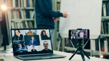 İnternetteki bir ders sırasında bir dizüstü bilgisayarın ve telefonun yakın plan fotoğrafını çek.