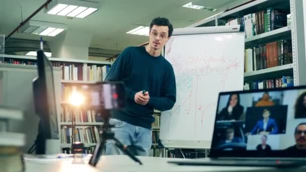 Учитель-мужчина, объясняющий геометрию дистанционно, используя свой телефон — стоковое видео