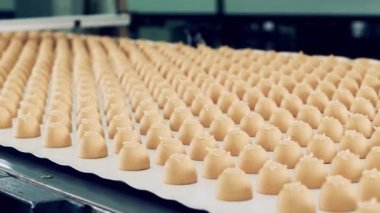 Taşıyıcı bant yavaş hareket ediyor ve üzerinde bir sürü tatlı var.