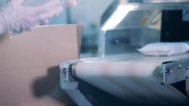 Fabrika işçisi paketleri kutulara koyuyor.