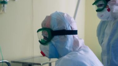 Hastane koğuşunda koruyucu giysi giymiş bir grup doktor. Coronavirus, covid-19 pandemik konsept.