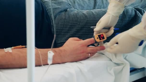 Доктор вимірює насиченість пацієнтів імпульсним оксиметром — стокове відео