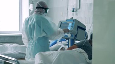 Coronavirus, covid-19 pandemik konsept. Havalandırma sistemi kırmızı bölgedeki bir doktor tarafından çalıştırılıyor.