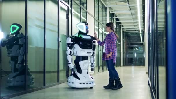 Kommunikation zwischen Mensch und Roboter. Teenagermädchen berührt menschenähnlichen Roboter — Stockvideo