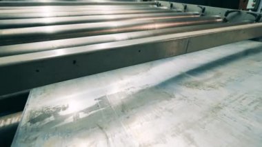 Metal plaka endüstriyel taşıyıcı boyunca ilerliyor.