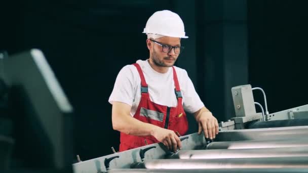 Trabajador masculino está ajustando un transportador rodante — Vídeos de Stock