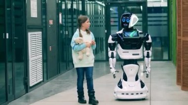 Robot oyuncak ayı taşıyan bir kızla konuşuyor. Gelecekçi cyborg, yenilikçi robot konsepti.