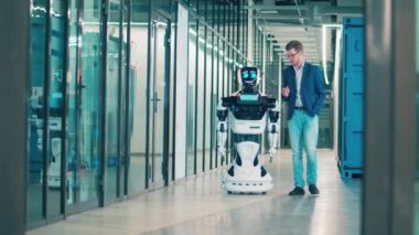 İş adamı ve sibernetik robot koridorda konuşuyorlar.