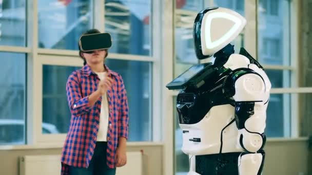 VRメガネの女の子はロボットと通信しています — ストック動画