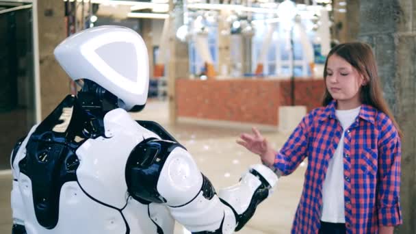 Küçük kız bir robotla el ele tutuşuyor.. — Stok video